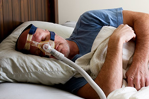 Man with CPAP nose mask sleeping soundly